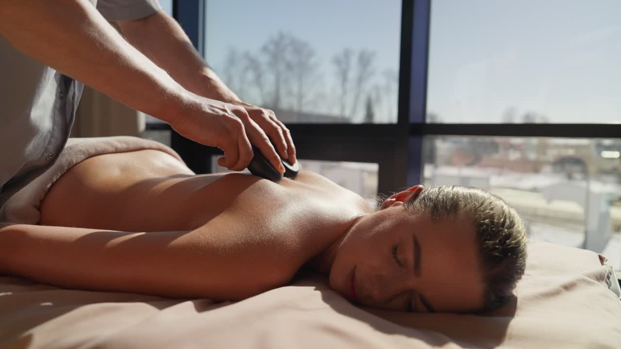 Kvinde modtager afslappende hot stone massage på et luksus-spa