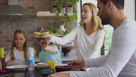 Familie-Beim-Essen-Am-Esstisch-In-Der-Küche-Im-Komfortablen-Zuhause-4k