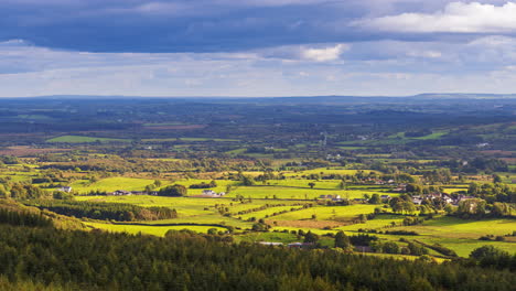 Zeitraffer-Der-Ländlichen-Landwirtschaftslandschaft-Mit-Lokalen-Bauernhäusern-Mit-Wald-Und-Hügeln-An-Einem-Bewölkten-Tag,-Von-Oben-Gesehen-Vom-Lough-Meelagh-In-Der-Grafschaft-Roscommon-In-Irland