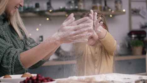 handheld video of mother and daughter having fun with flour