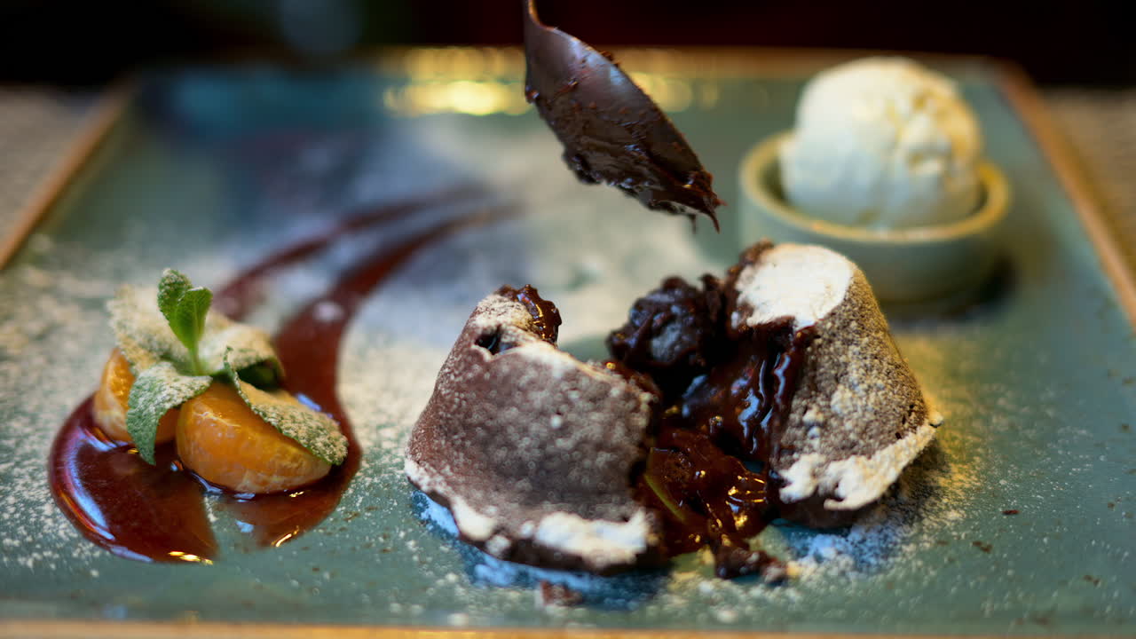 Chocolate lava cake with ice cream and orange decoration in a restaurant