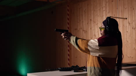 person wearing safety equipment loading bullets cartridge in pistol