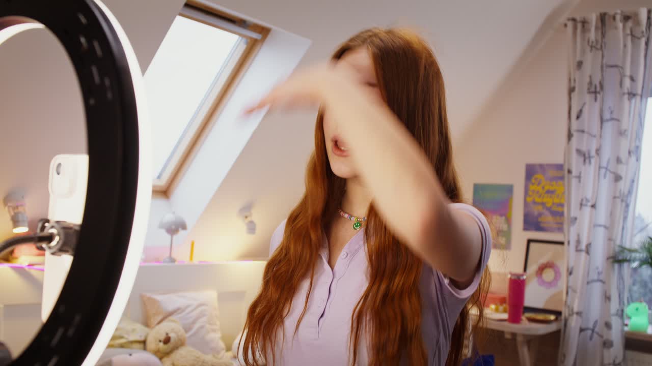 십대 소녀가 침실에서 비디오 블로그를 녹음하고 있습니다.