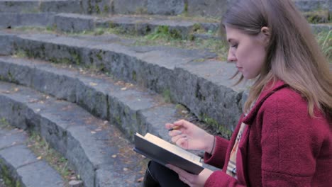 woman writing in a notebook outdoors