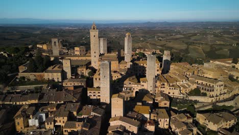 toma de cierre cinematográfica - el avión no tripulado vuela lejos de las torres medievales en san gimignano, italia