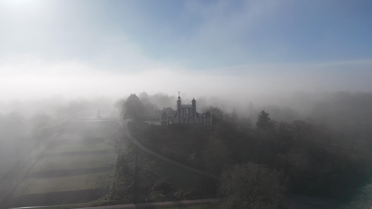 Experience breathtaking drone footage of the Royal Observatory and Park in Greenwich, London, shrouded in atmospheric mist, capturing its timeless beauty and iconic architecture.