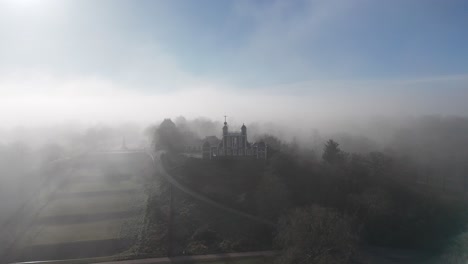 experience breathtaking drone footage of the royal observatory and park in greenwich, london, shrouded in atmospheric mist, capturing its timeless beauty and iconic architecture.