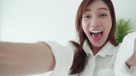 tracking in asian woman with a white shirt spins frottage feel good with a selfie video