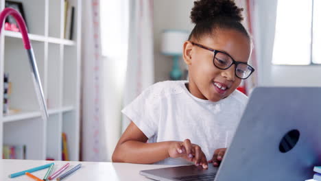 Junges-Mädchen-Mit-Brille-Sitzt-Am-Schreibtisch-Im-Schlafzimmer-Und-Benutzt-Einen-Laptop