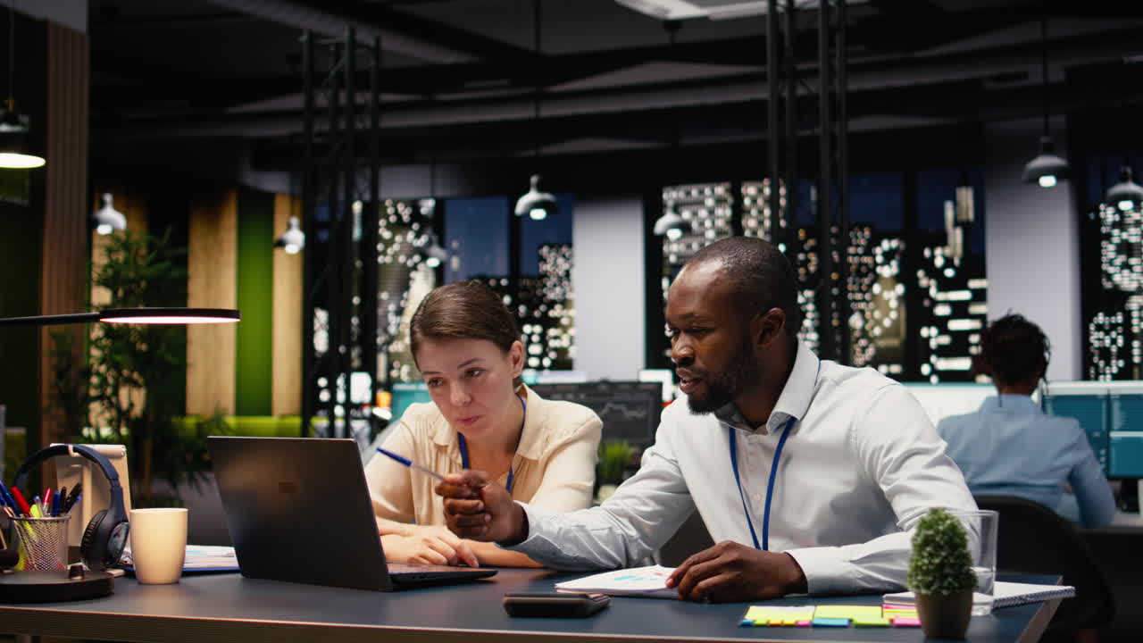 Corporate staff collaborating in a shared workspace late at night