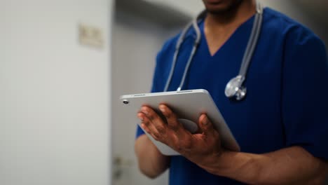 médico usando una tableta en un pasillo del hospital