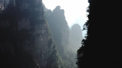 Drone-Volando-A-Través-De-Pilares-De-Piedra-De-Zhangjiajie-Con-Luz-Solar-Escénica