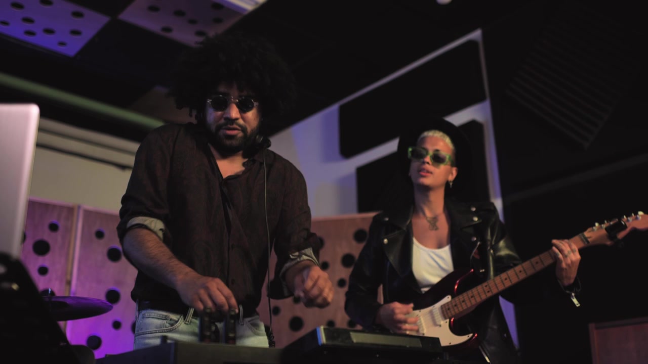 Energetic Musicians Playing Instruments in a Studio with Neon Lights