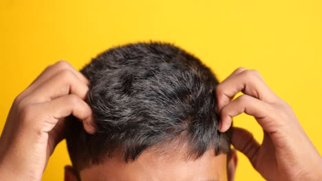 Teenage-boy-scratching-head-against-black-background