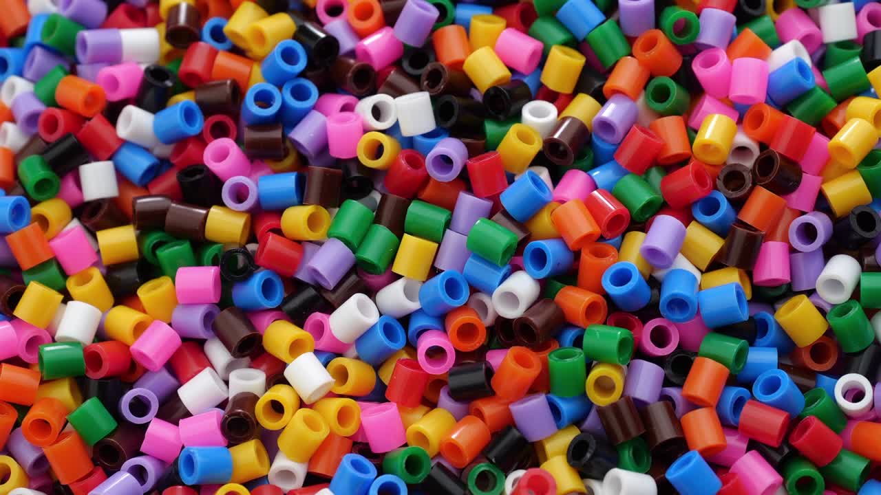 Molte perline termofusibili in plastica colorate. Primo piano