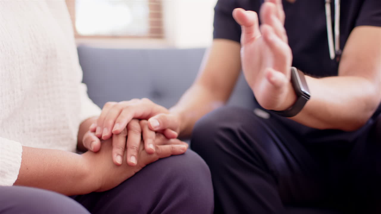 Supporting senior woman, physiotherapist holding hands during therapy session