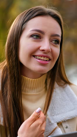 young charming lady working with laptop. beautiful lady online studying outdoor in park. vertical video