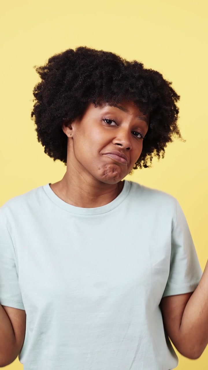 Young African American Woman Shrugging with an Expression of Uncertainty