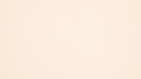 white paper for text and autumn leaves around appear on beige background. stop motion