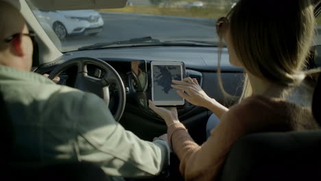 Couple using digital tablet in car