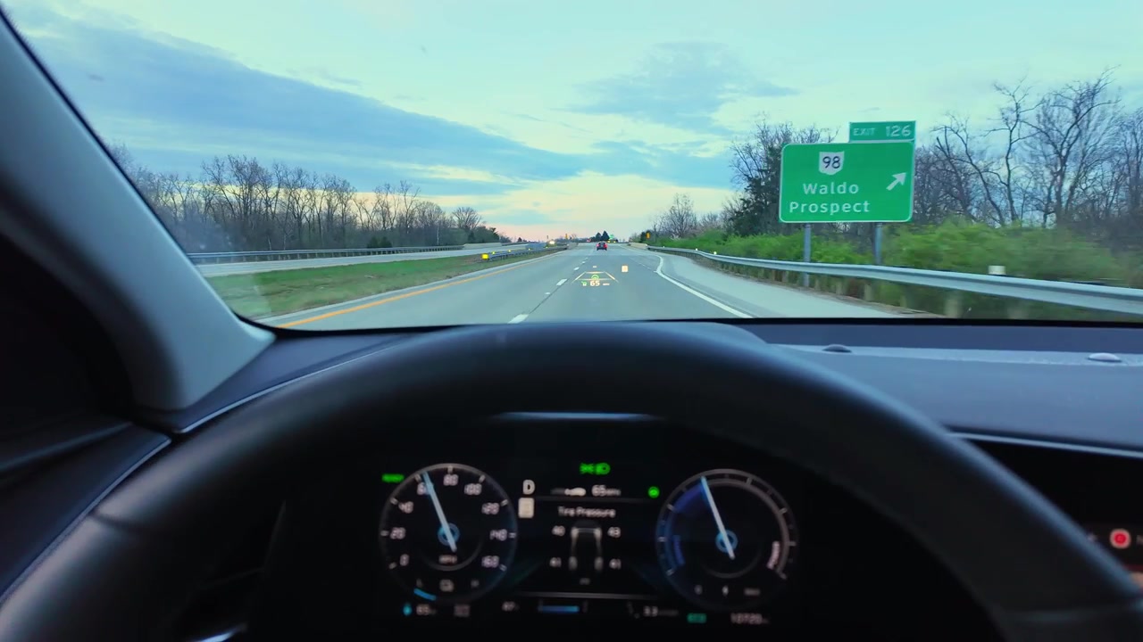 Driving a modern car on highway with heads-up display projecting navigation data