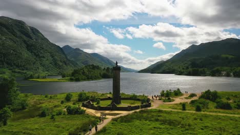 Aerial-of-Scottish-Landmark,-Glenfinnan-Monument-And-Loch-Shiel,-Glenfinnan,-Scottish-Highlands,-Scotland,-United-Kingdom