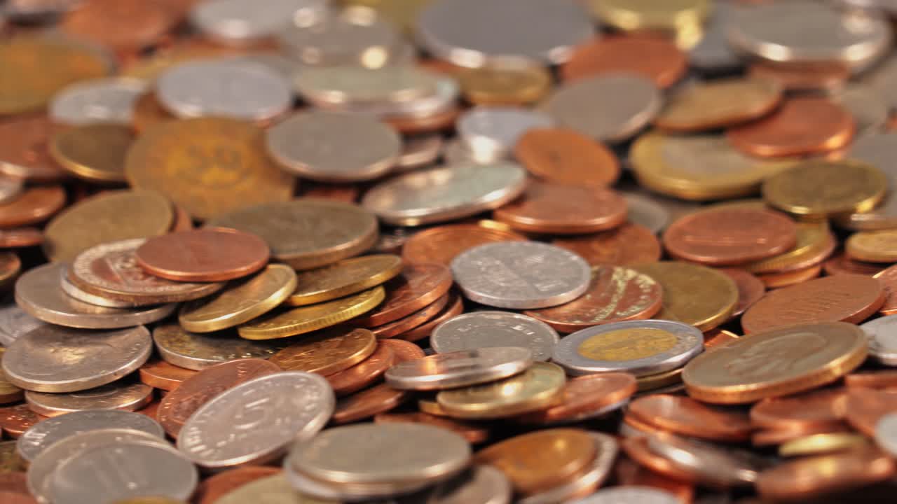 Coins scattered on a surface during daylight in a simple setting