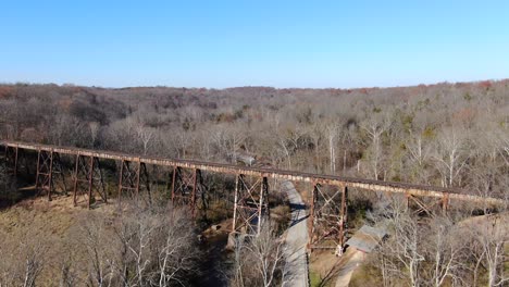 disparo aéreo empujando hacia adelante a lo largo de un camino hacia el papa lick caballete de ferrocarril en louisville kentucky, con un bosque en el fondo en un día soleado