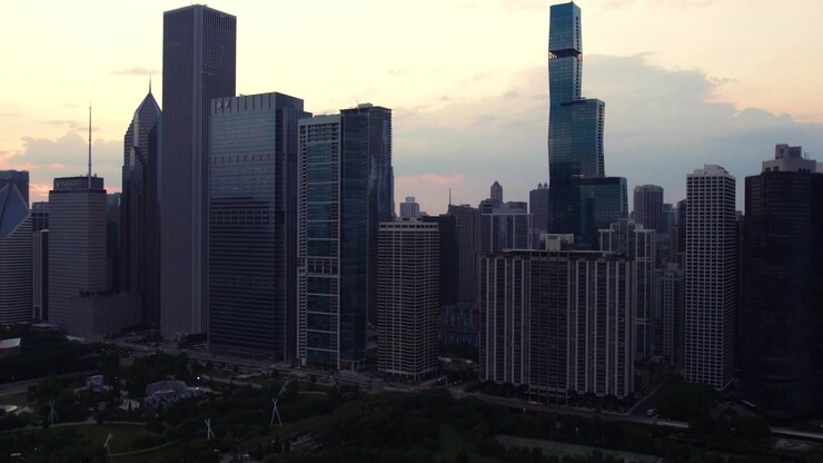 Vista aérea de drone do denso horizonte do centro de Chicago e arranha-céus sob a luz suave do pôr do sol com nuvens dramáticas ao entardecer
