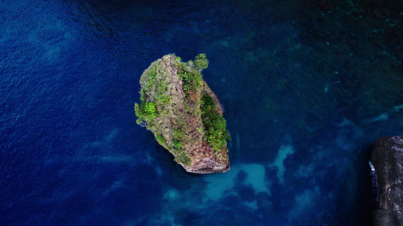 Formazione rocciosa con vegetazione nell'oceano a Nusa Penida, Bali, Indonesia