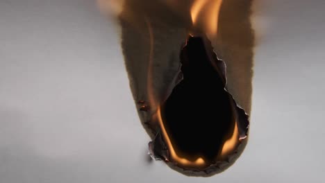 hole burnt in a sheet of paper, completely burnt leaf. paper burns, smoke and turns into ashes