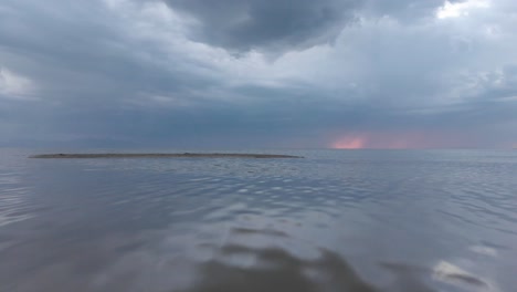 un hombre está de pie en un sofá de cuero en el medio del gran lago salado en una noche tormentosa