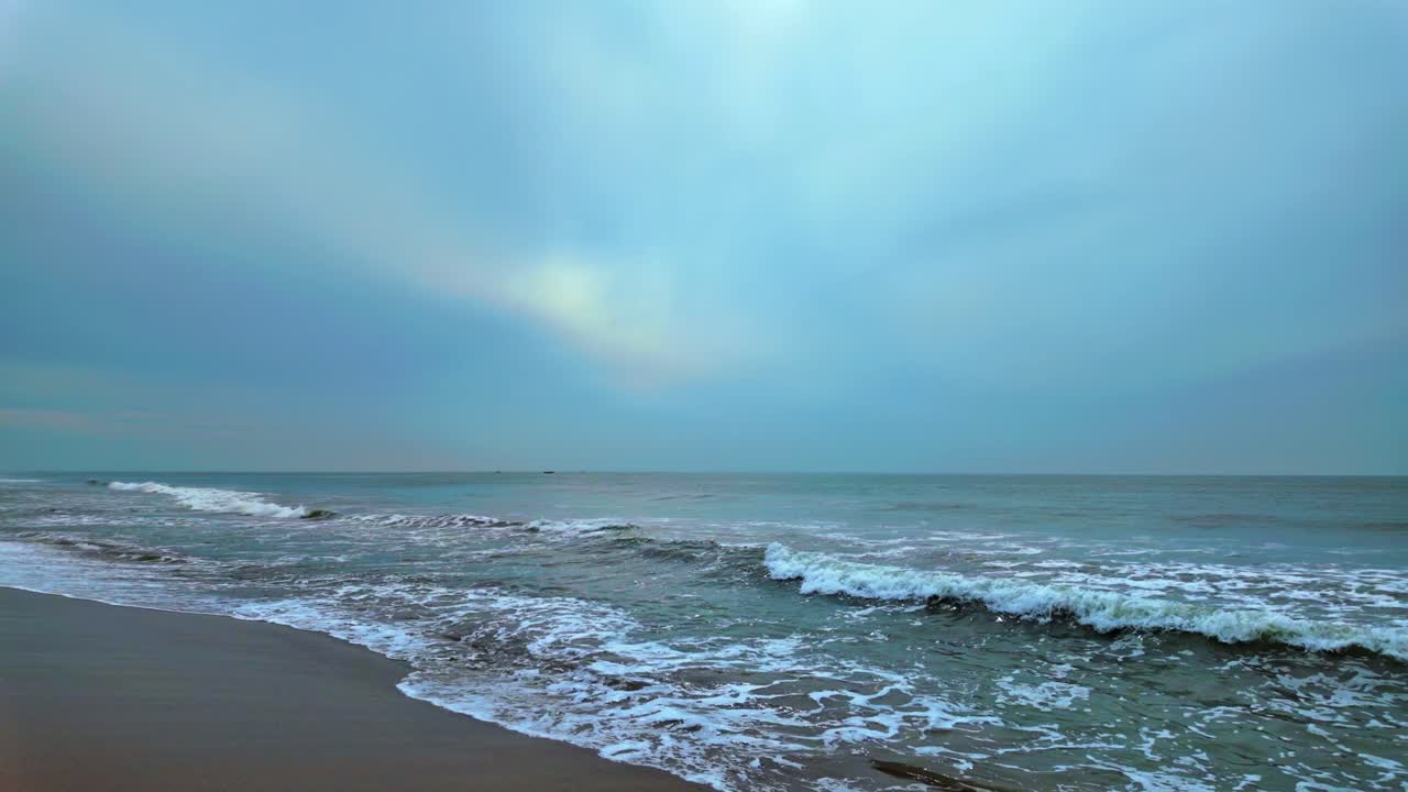 Beautiful scene of waves on deserted beach on cloudy day. Static, slomo