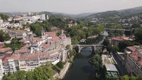 Spectacular-aerial-pan-shot,-national-monument-monastery-of-Sao-Goncalo-and-roman-bridge-in-Amarante