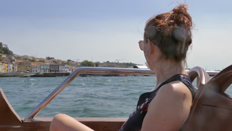 profile of a beautiful woman during sightseeing on a boat in the city of porto, portugal