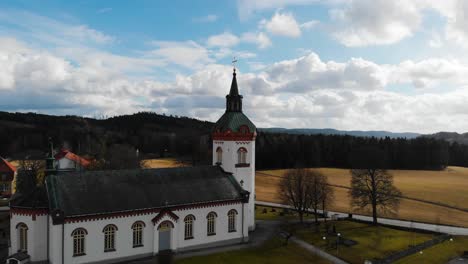 Aerial---Björketorps-Church-in-Rävlanda,-Härryda,-Sweden,-rising-scenic-shot