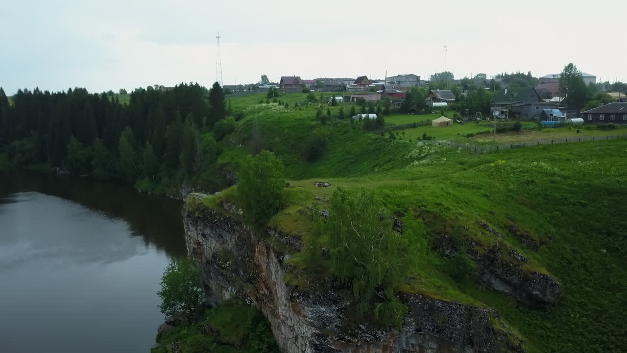 Rustikales Dorf an einer Flussklippe, Luftaufnahme