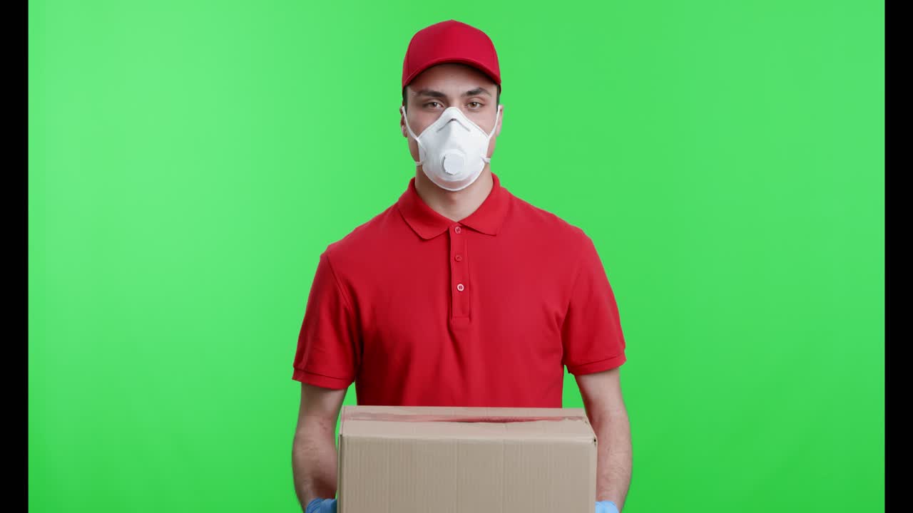 Fattorino con dispositivi di protezione che tiene una scatola.