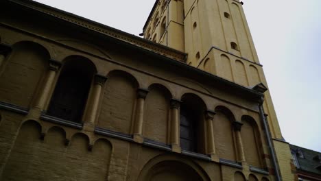 pan to the church made of sandstone, with many stone arches and a high church tower