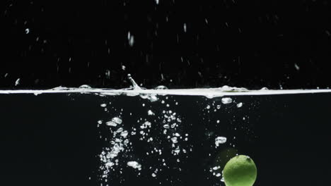 video of two limes underwater with copy space over black background