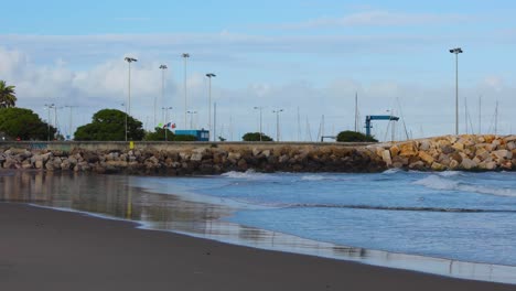 Yachthafen-Mit-Booten-Und-Einigen-Wellen,-Die-Auf-Den-Strand-In-Lissabon,-Portugal,-Krachen