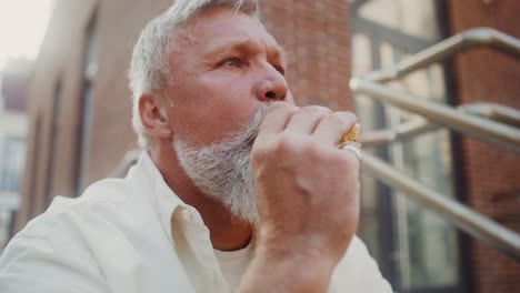 older man eating outdoors