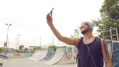 Junge-Mit-Handy-Auf-Einem-Skatepark