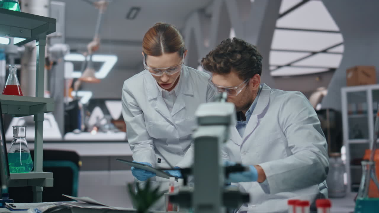Lab workers experimenting samples looking at computer data in clinic close up