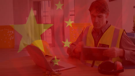 chinese flag animation over construction worker using tablet and laptop in office