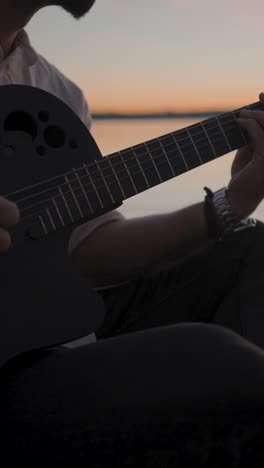 Playing Guitar at Sunset by the Water