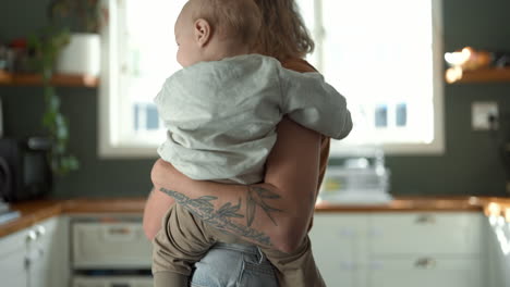 mother holding baby in kitchen