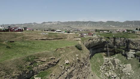 aerial view of waterfall and village in mountains