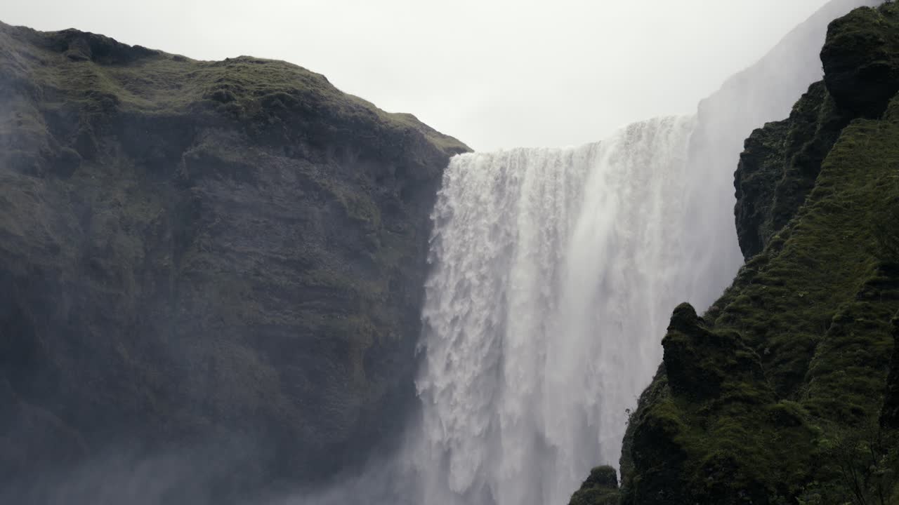 una toma amplia de una cascada masiva derramando agua sobre el precipicio de la perdición