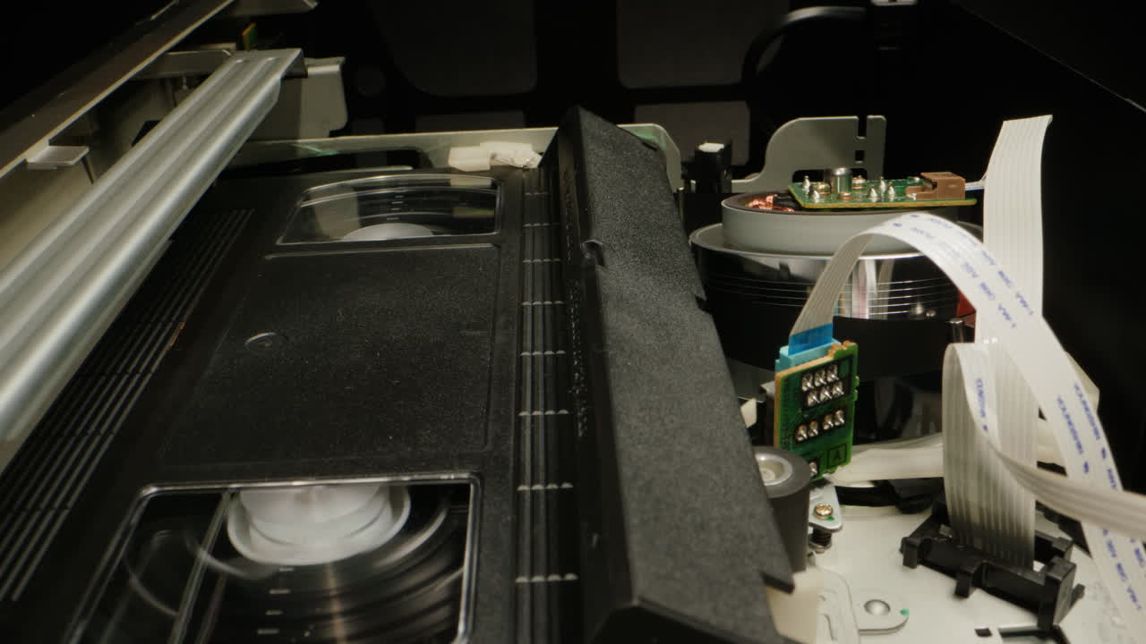 Old video recorder inside close-up, VHS. Retro player in neon blue light, vintage video cassette broadcasting, audio tape.